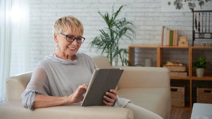 Eine Frau liest am Tablet die Geschäftsberichte
