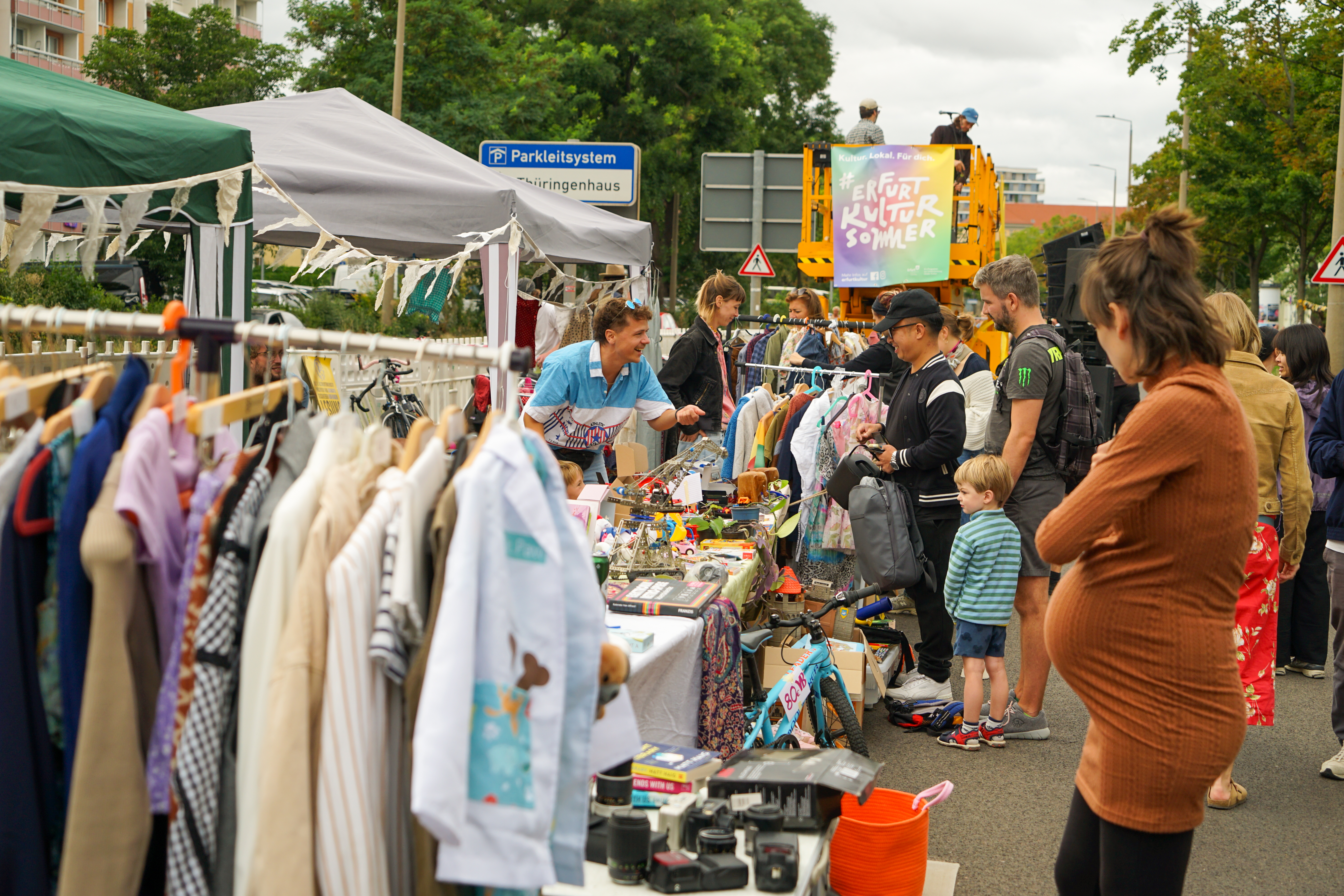 Flohmarkt beim Hebebühnenkonzert Flohmarktstände mit Kleidung und Besuchern auf einer Straße