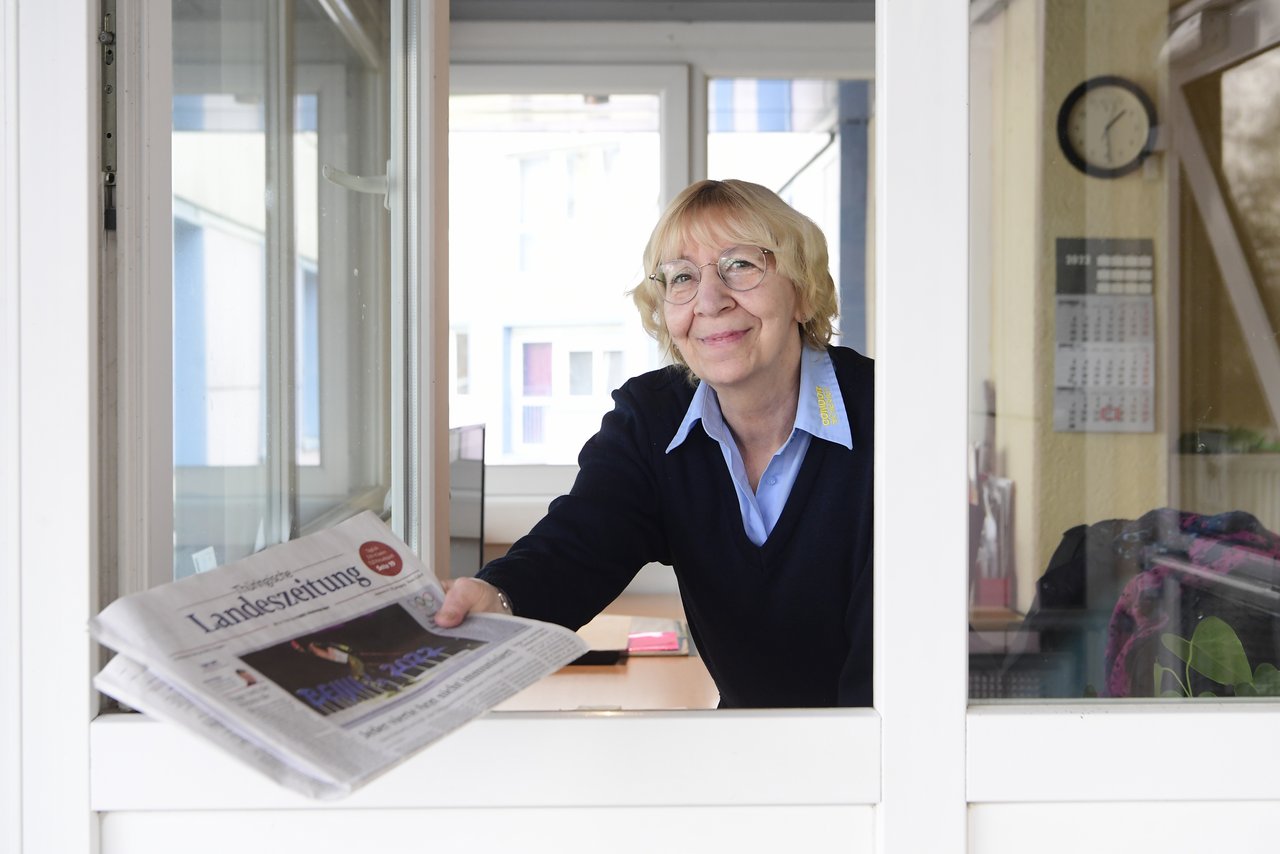 Concierge in der Györer Straße reicht Tageszeitung durchs Fenster