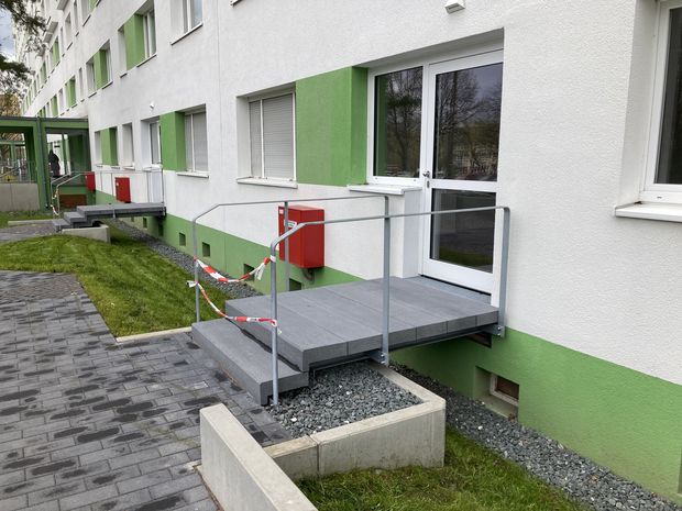 Notausgänge an einem Wohngebäude, die als kleine Brücke zu den Außenanlagen führen