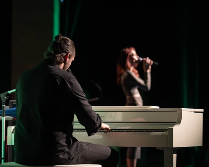 Ein Mann spielt Klavier und eine Frau singt