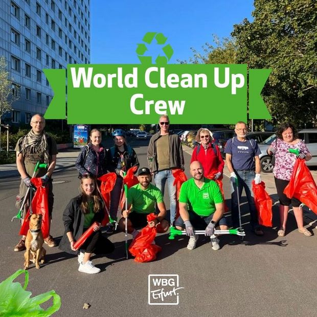 10 Personen verschiedenen Alters und Geschlechts posieren auf einer Straße mit Müllsäcken und Abfallgreifern