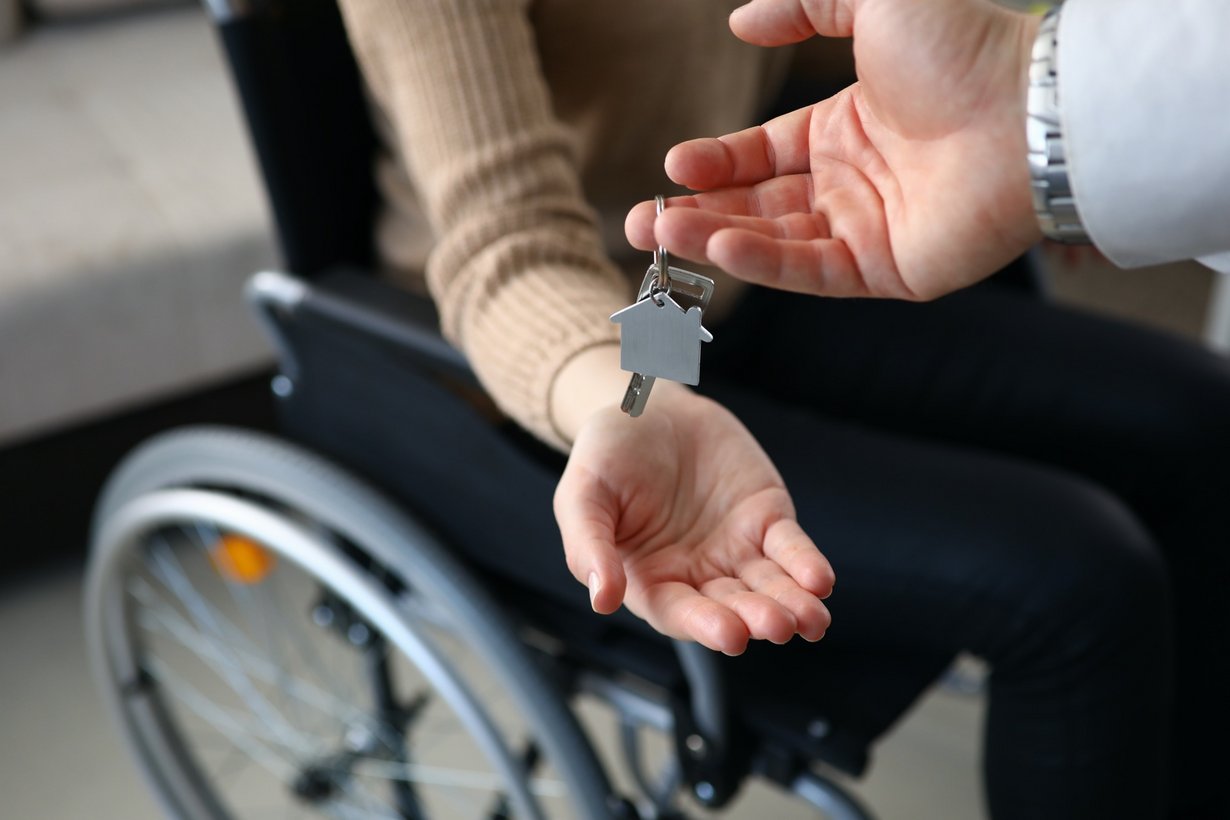 Person im Rollstuhl erhält Schlüssel