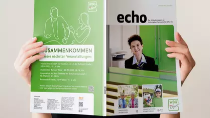 Person hält das echo Mitgliedermagazin aufgeklappt vor dem Gesicht