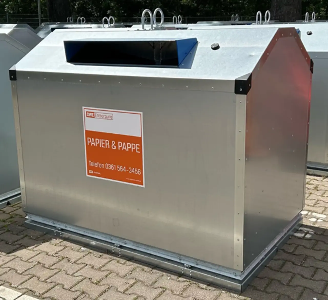 Großer silberner Papier- und Pappe-Container im Freien