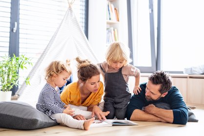 Familie mit zwei Kindern liest gemeinsam