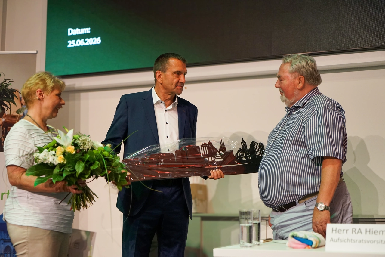 2 Mitglieder des Vorstandes übergeben ein Geschenk an den alten Aufsichtsratsvorsitzenden